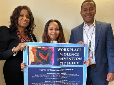 Three people posed for photo holding a Workplace Violence Prevention Tip Sheet