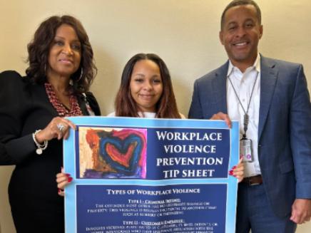 Three people posed for photo holding a Workplace Violence Prevention Tip Sheet