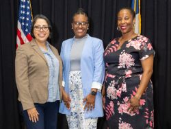 Three women posed, smiling for photo