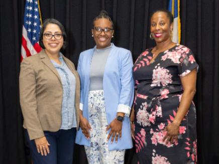Three women posed, smiling for photo