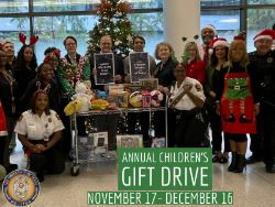 People smiling for photo with toy donations dressed in uniform