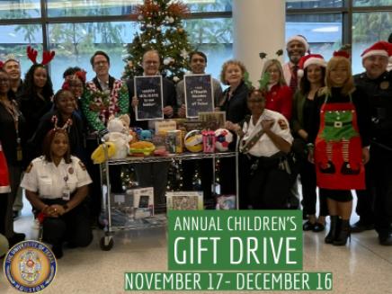 People smiling for photo with toy donations dressed in uniform
