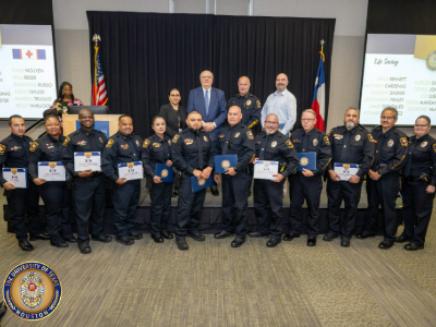 Group of UT Police employees posed for photo holding certificates